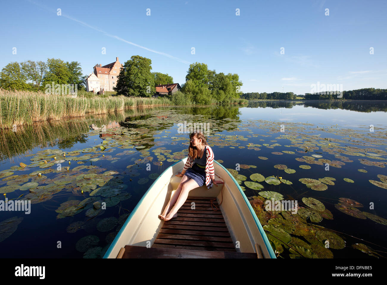 Young Woman in a rowing boat on lake Ulrichshusen, Ulrichshusen castle, Mecklenburg-West Pomerania, Germany Stock Photo