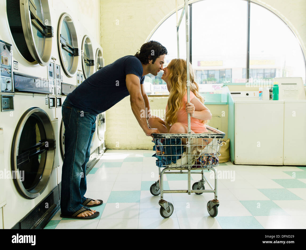 A young man leans over to feel the nose of a beautiful lady who sits on