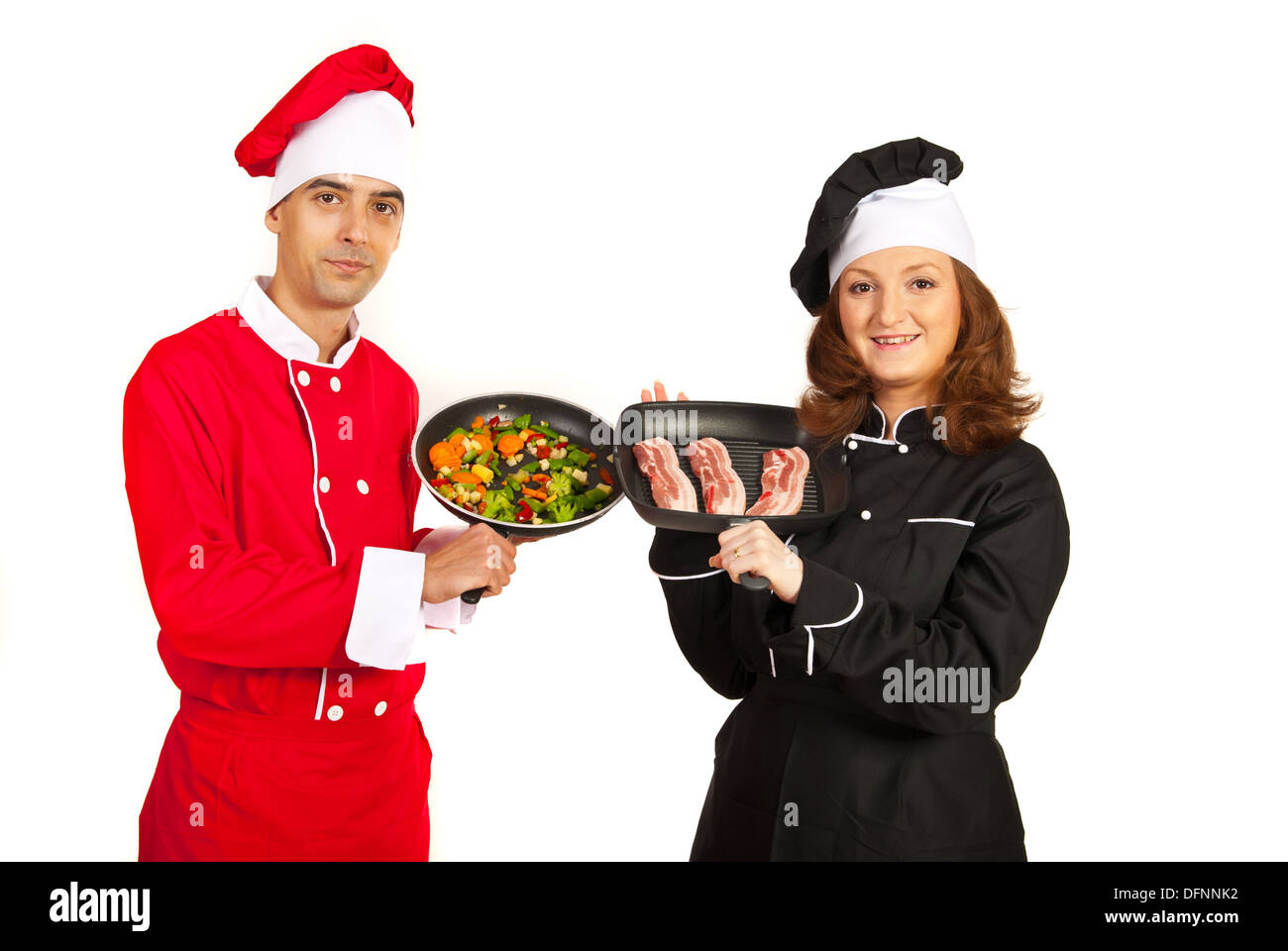Chefs showing frying pans with vegetables and meat Stock Photo