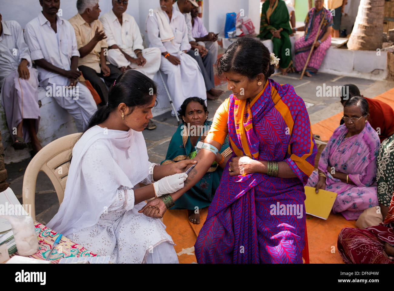 Indian nurse taking blood samples from patients at Sri Sathya Sai Baba mobile outreach hospital clinic. Andhra Pradesh, India Stock Photo