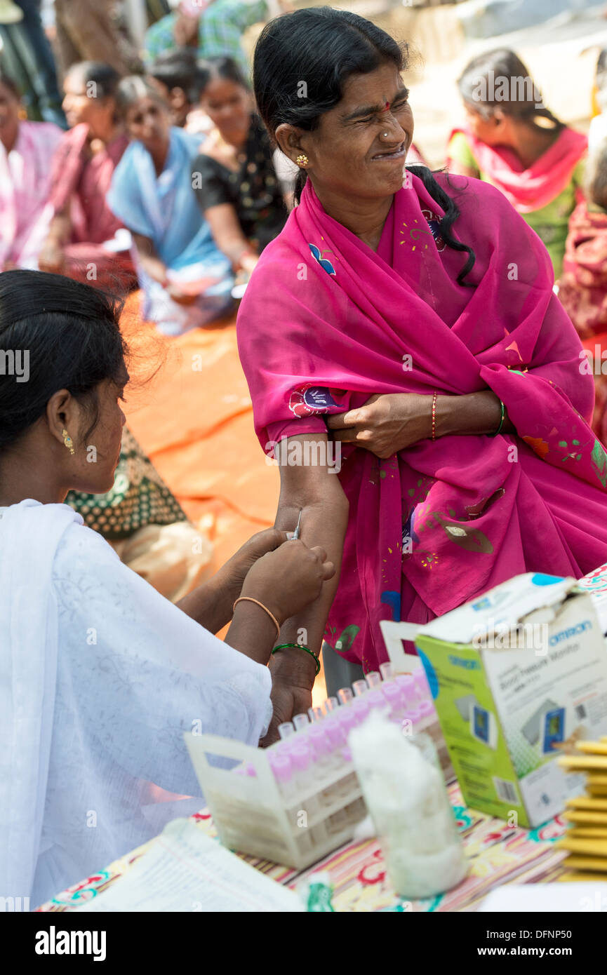 Indian nurse taking blood samples from patients at Sri Sathya Sai Baba mobile outreach hospital clinic. Andhra Pradesh, India Stock Photo