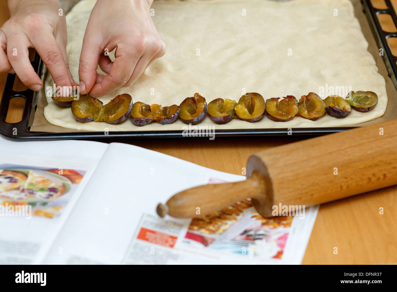 preparing, baking plum cake, placing plums on dough Stock Photo