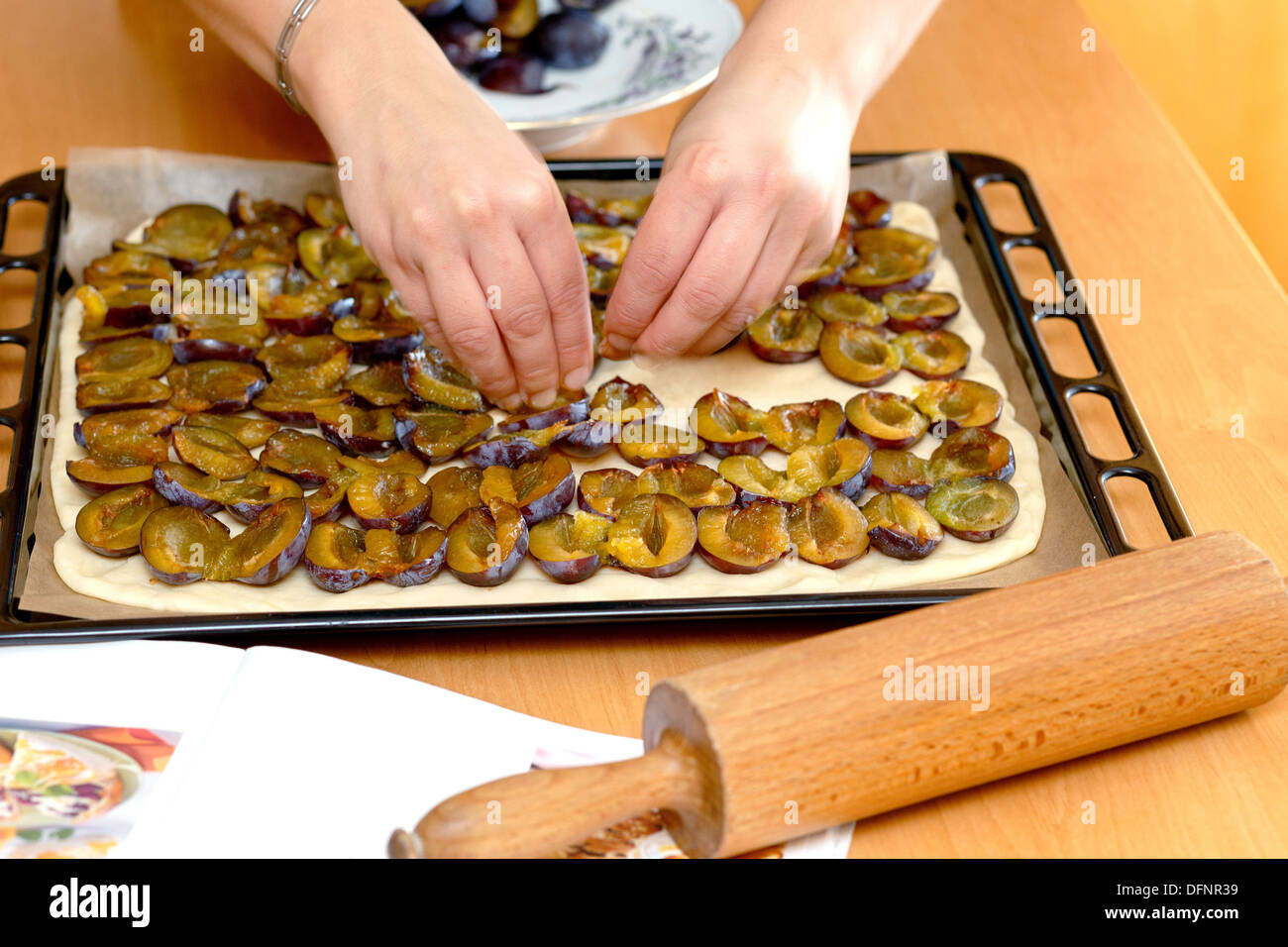 preparing, baking plum cake, placing plums on dough Stock Photo