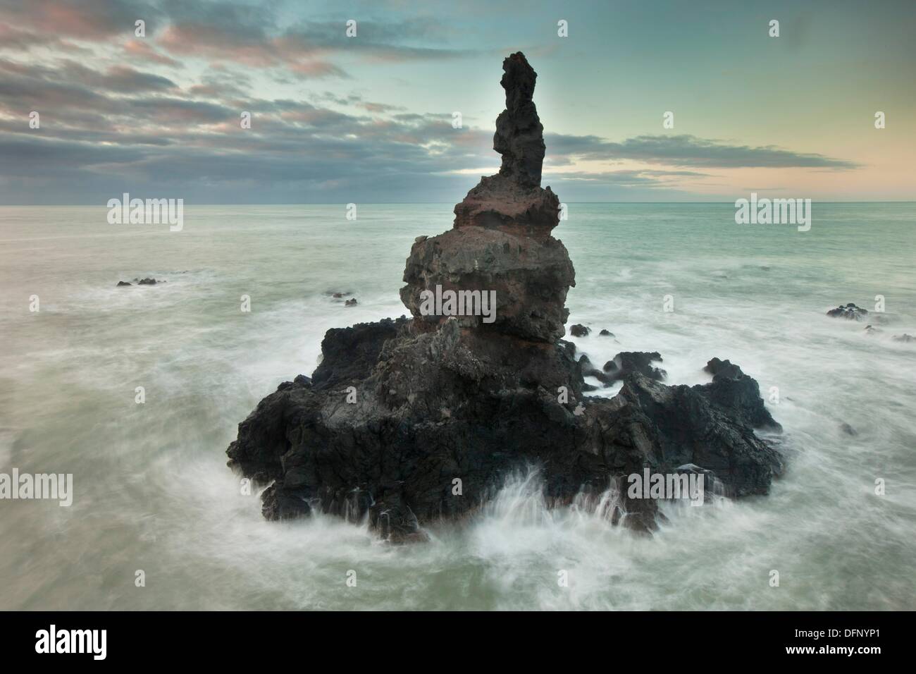 Sea stack off Tumbledown Bay, dawn, southern bays of Banks Peninsula, Canterbury, New Zealand. Stock Photo