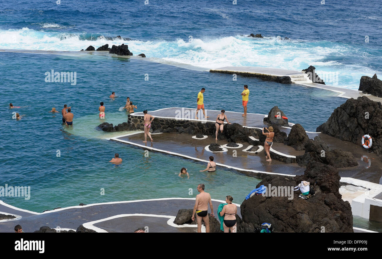 Madeira Portugal. tourists swimming and bathing in the lava rock pools in the resort of Porto Moniz Stock Photo