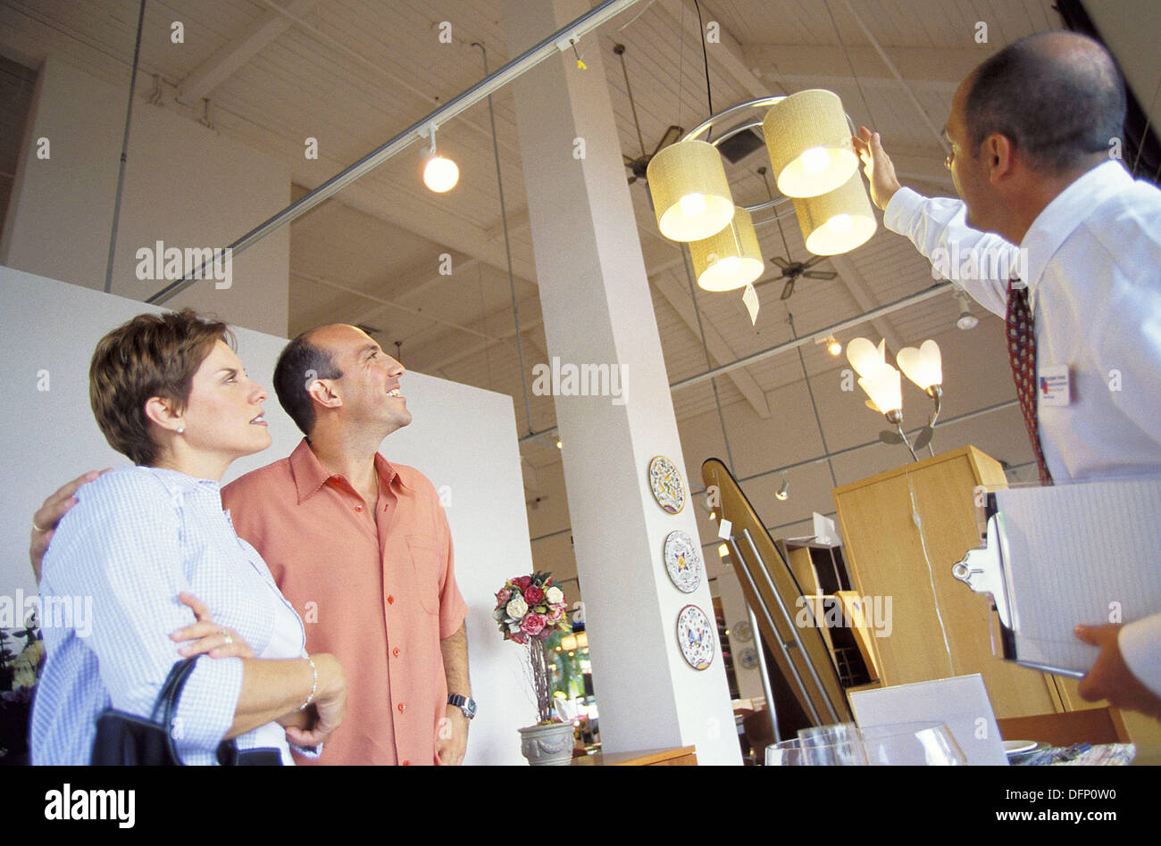 Couple and salesman in furniture shop Stock Photo Alamy