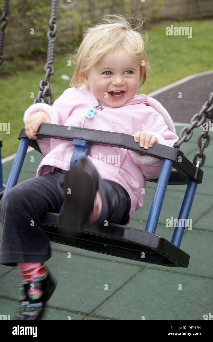 18 month old girl swinging, smiling Stock Photo Alamy