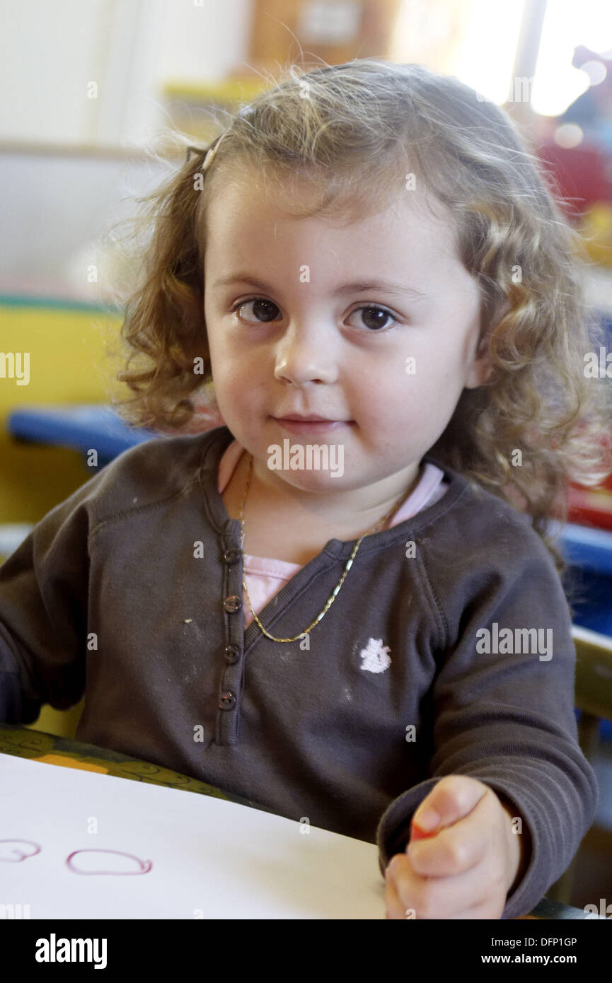 https://c8.alamy.com/comp/DFP1GP/3-year-old-girl-sitting-at-nursery-drawing-smiling-off-camera-DFP1GP.jpg