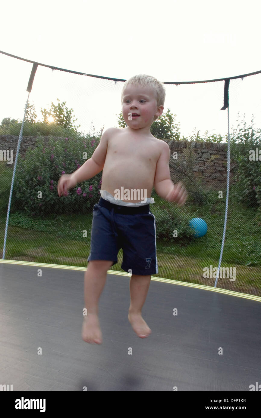 3 year old boy bouncing on a trampoline Stock Photo - Alamy