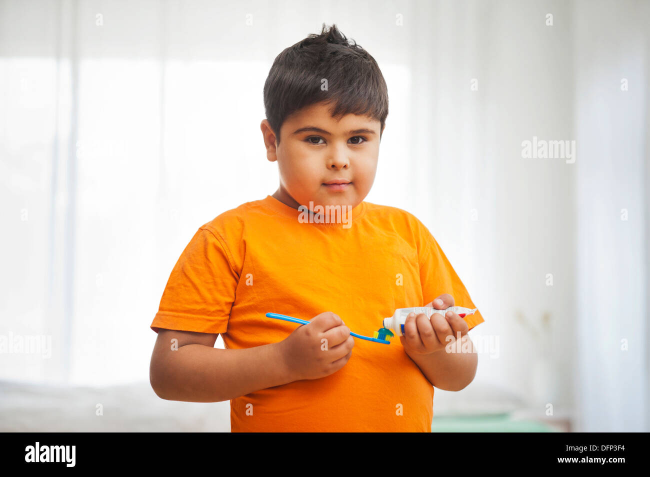 Boy squeezing toothpaste on a toothbrush Stock Photo Alamy
