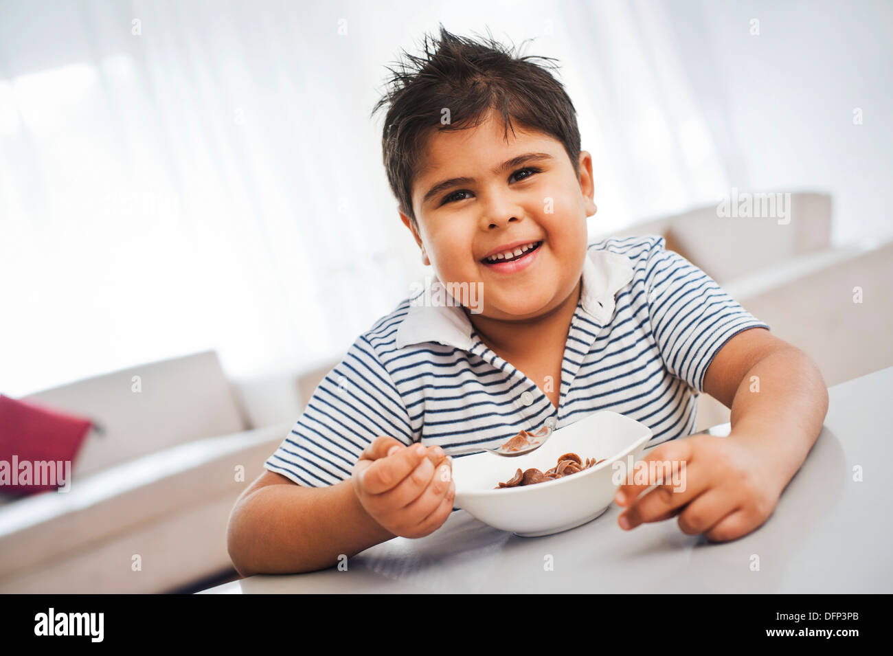 Boy eating chocolate corn flakes Stock Photo - Alamy