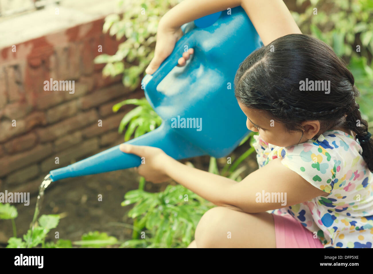 Girl watering plants with a watering can Stock Photo Alamy