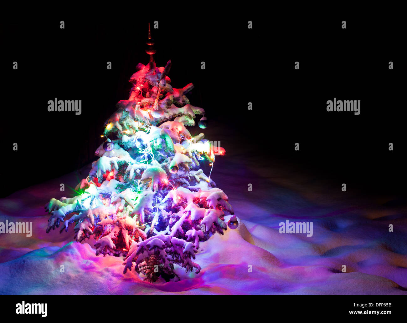 Luminous New Year's tree in the banks of snow. Stock Photo