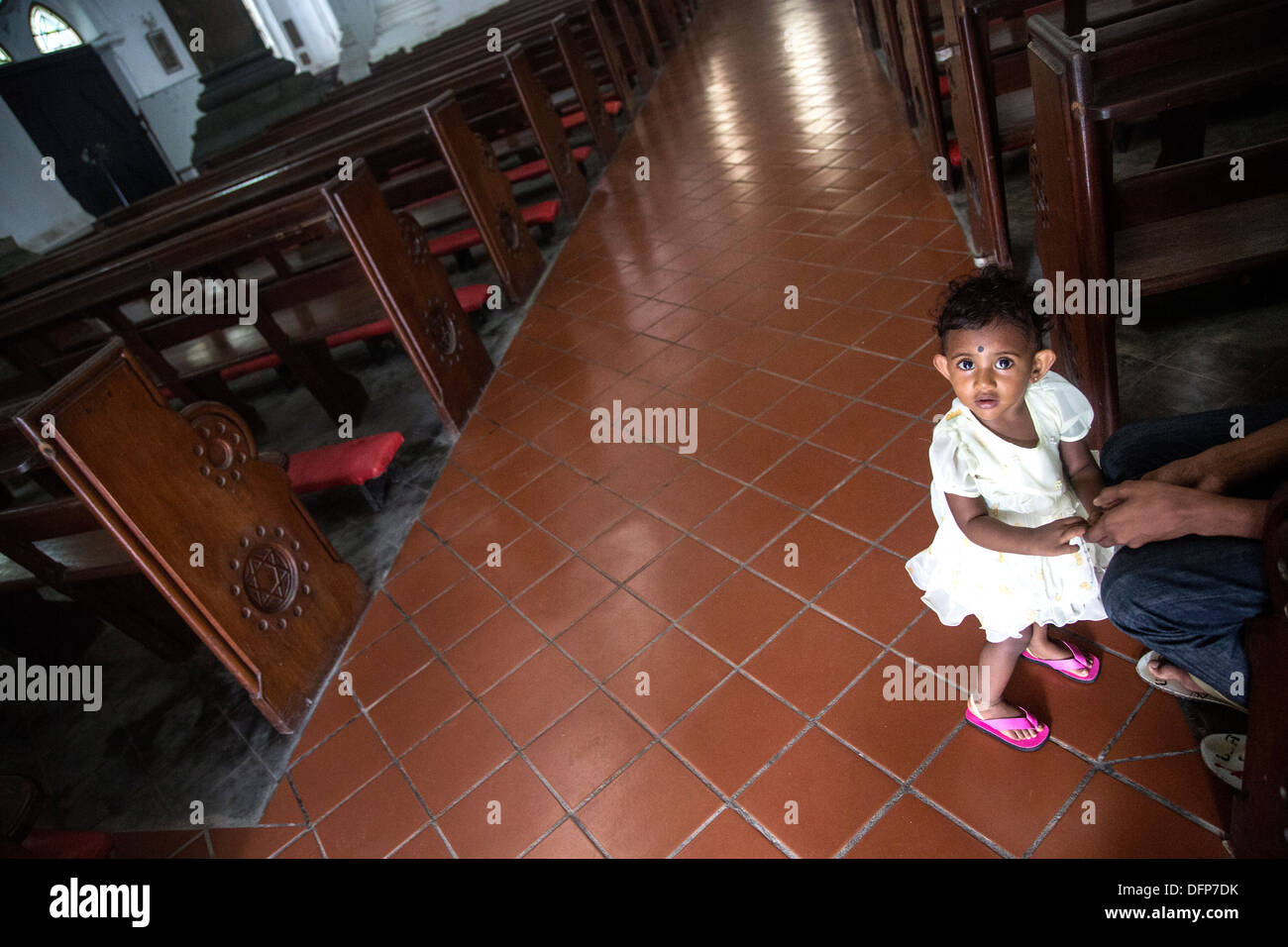 young girl bookies in church pink shoes Stock Photo