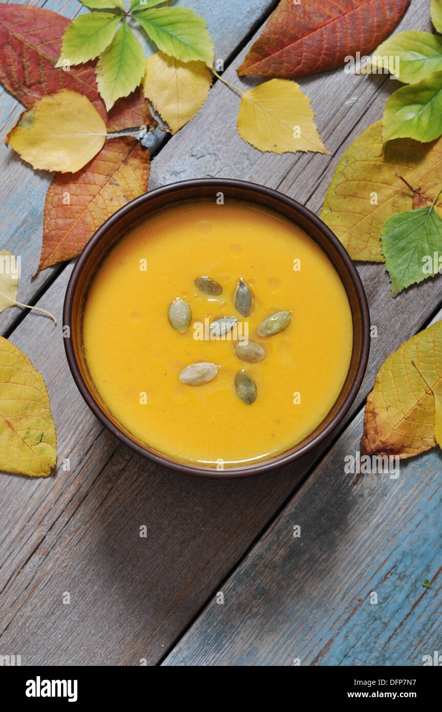 Bowl of pumpkin soup on rustic wooden table. Stock Photo