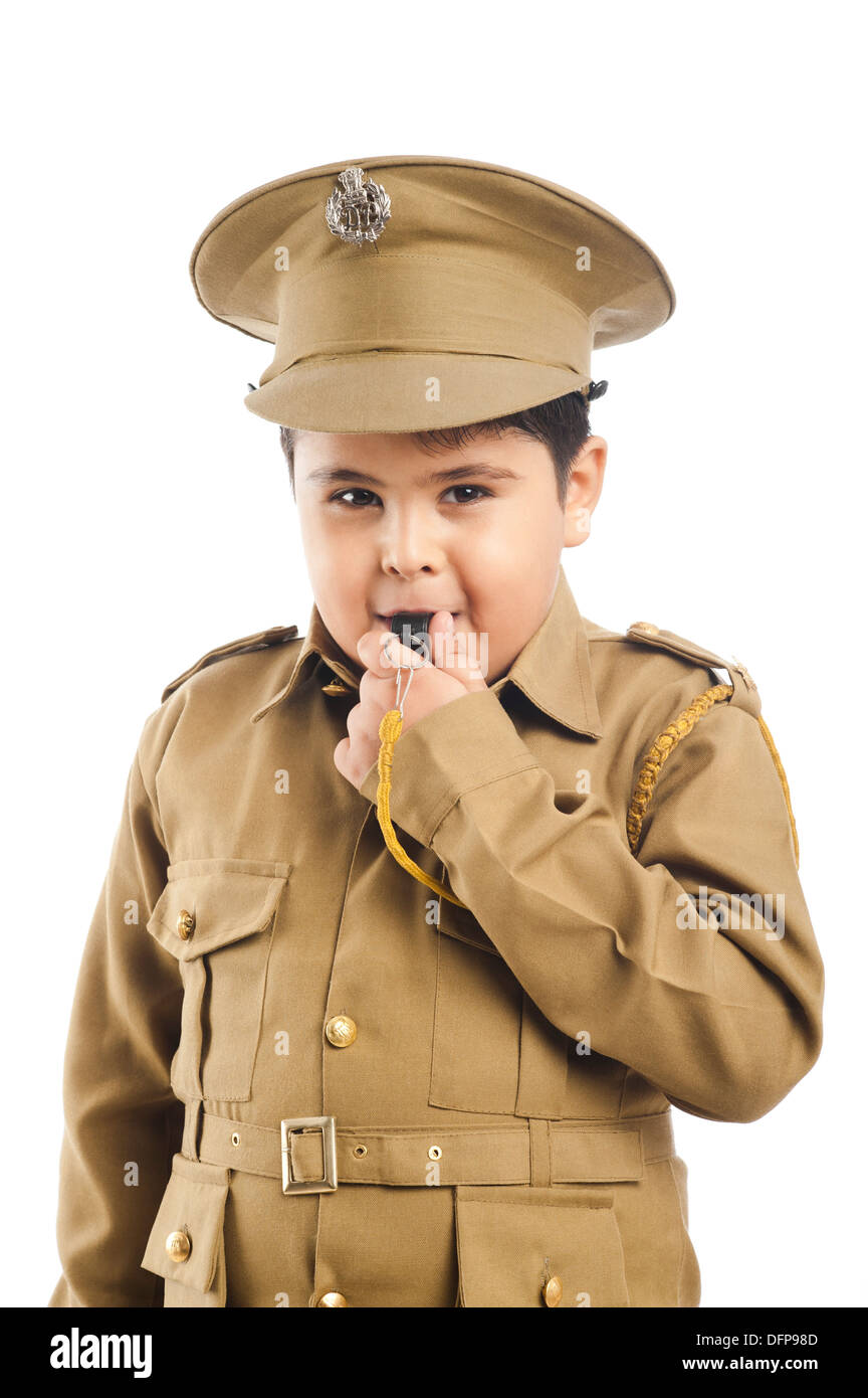 Close-up of a boy dressed as a police uniform blowing a whistle Stock Photo