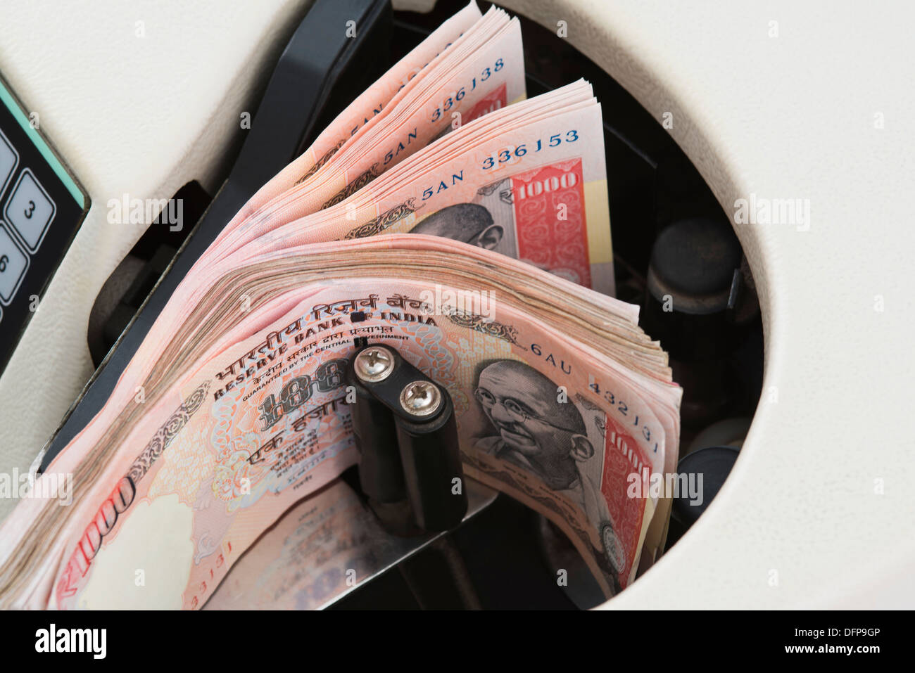 One Thousand Indian banknotes being counted in a machine Stock Photo