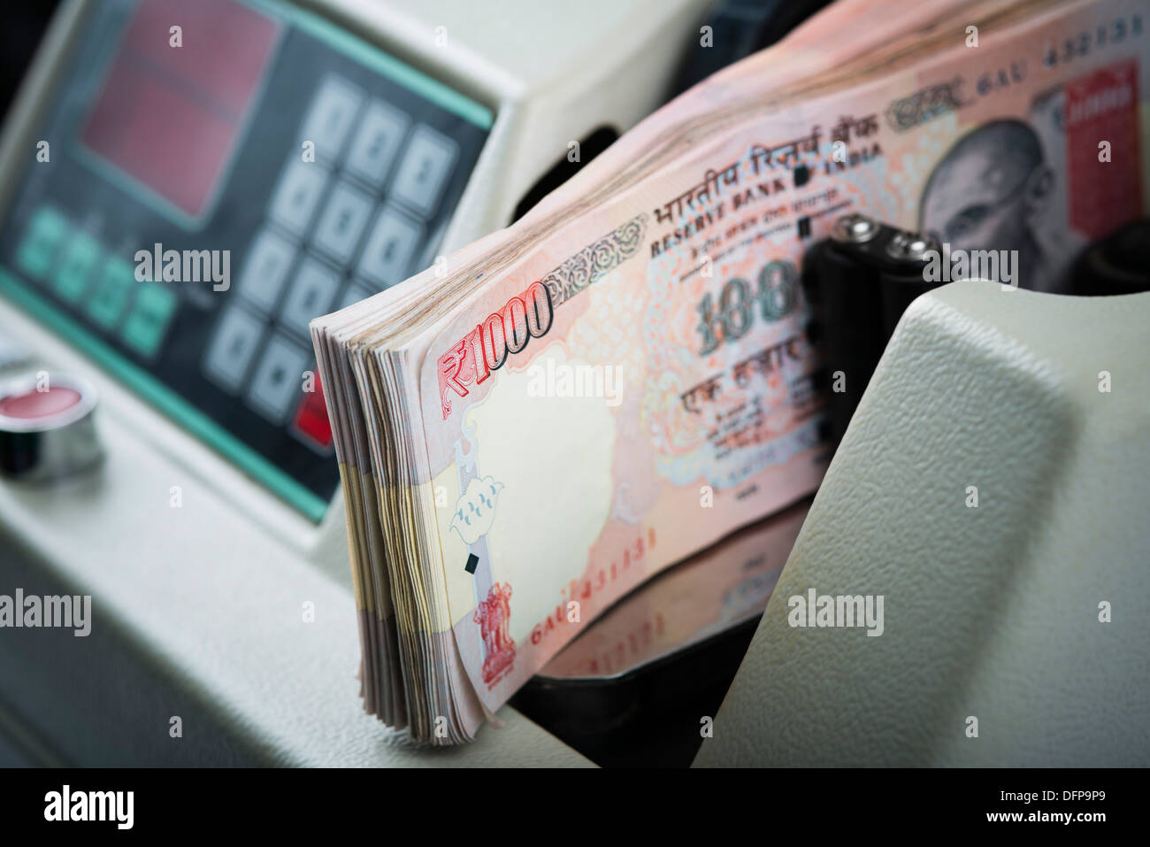 One Thousand Indian banknotes being counted in a machine Stock Photo