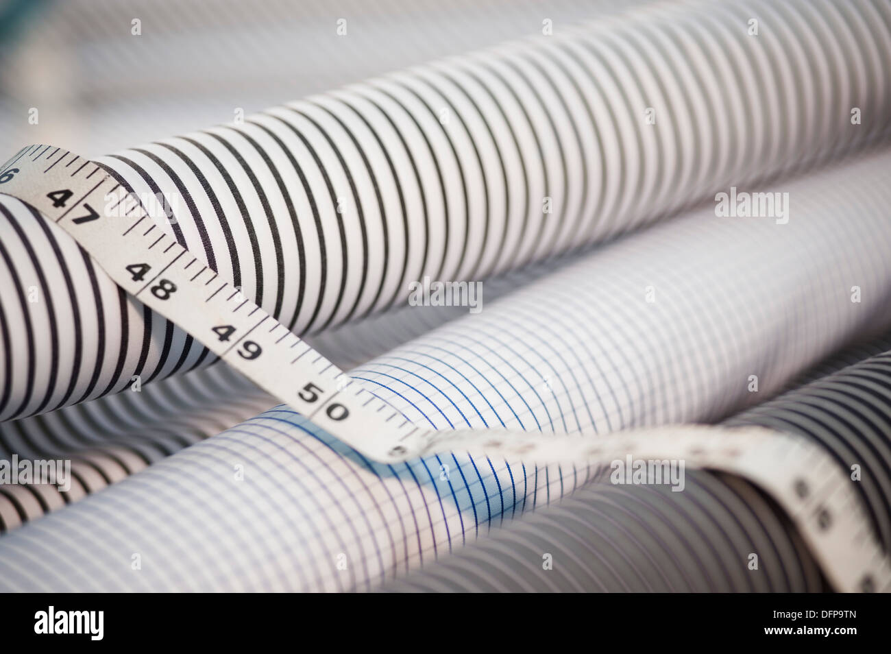 Close-up of tape measure on spools of fabric Stock Photo