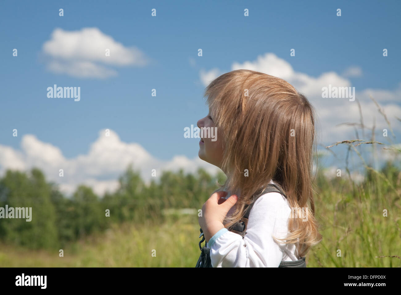 little girl looks at the sky with clouds Stock Photo - Alamy