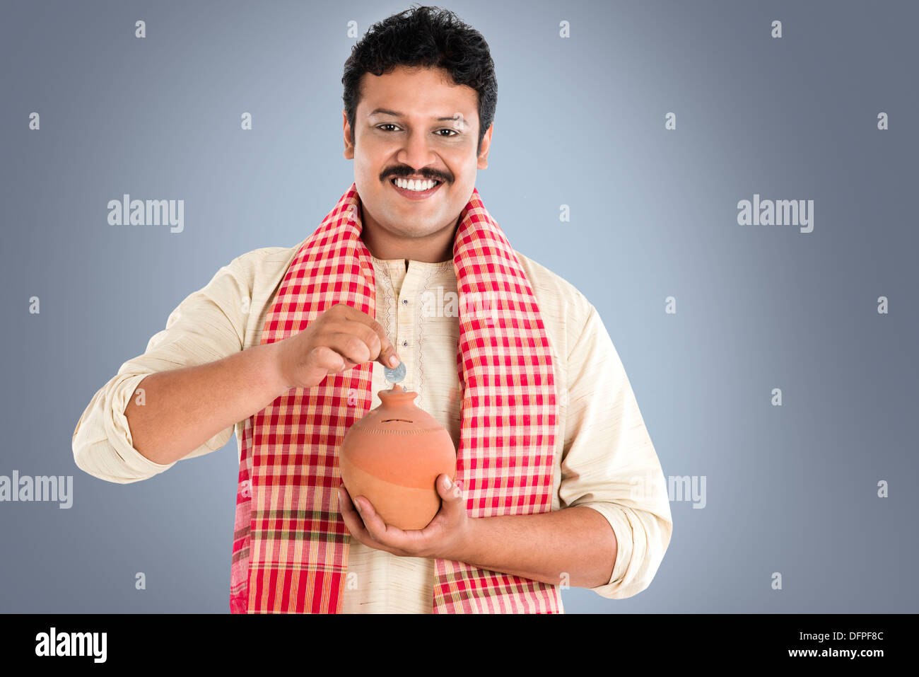Portrait of a man putting coin into a piggy bank Stock Photo - Alamy