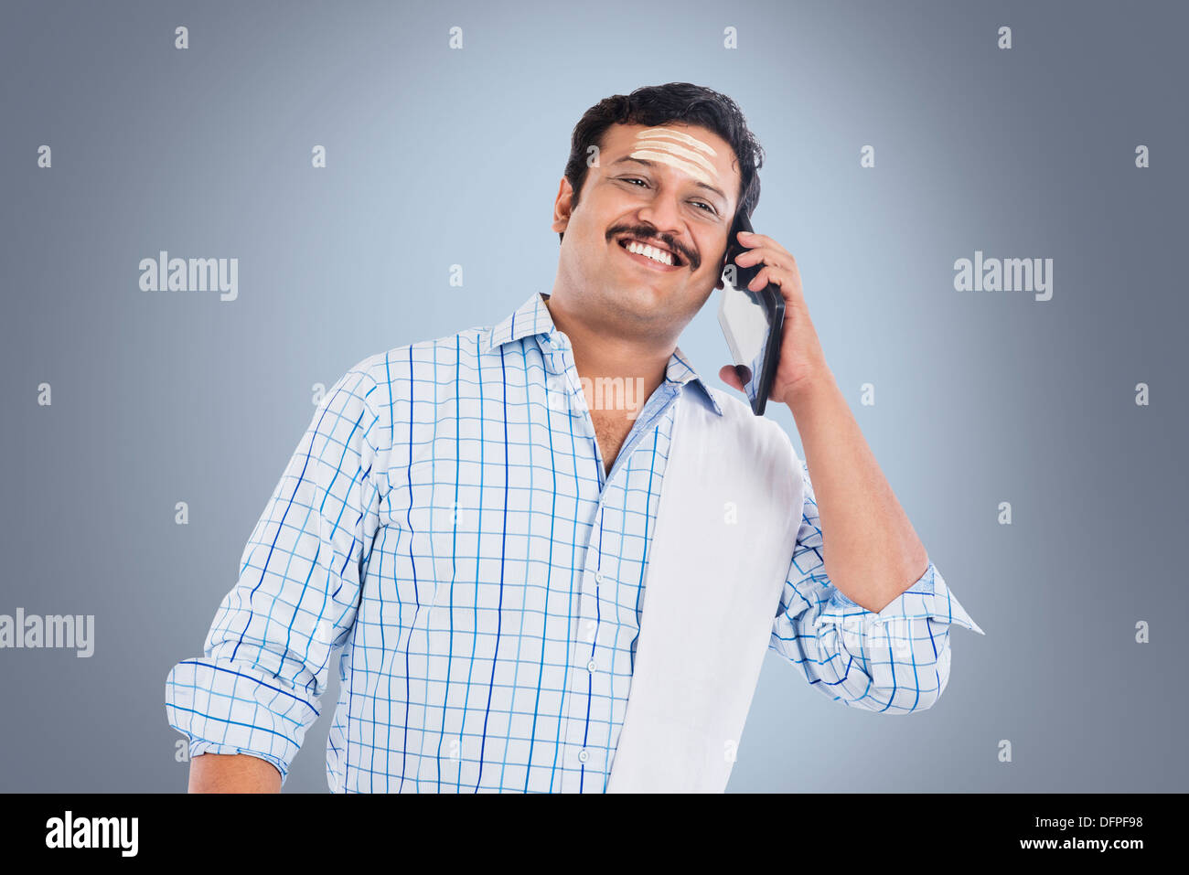 South Indian man talking on a mobile phone and smiling Stock Photo