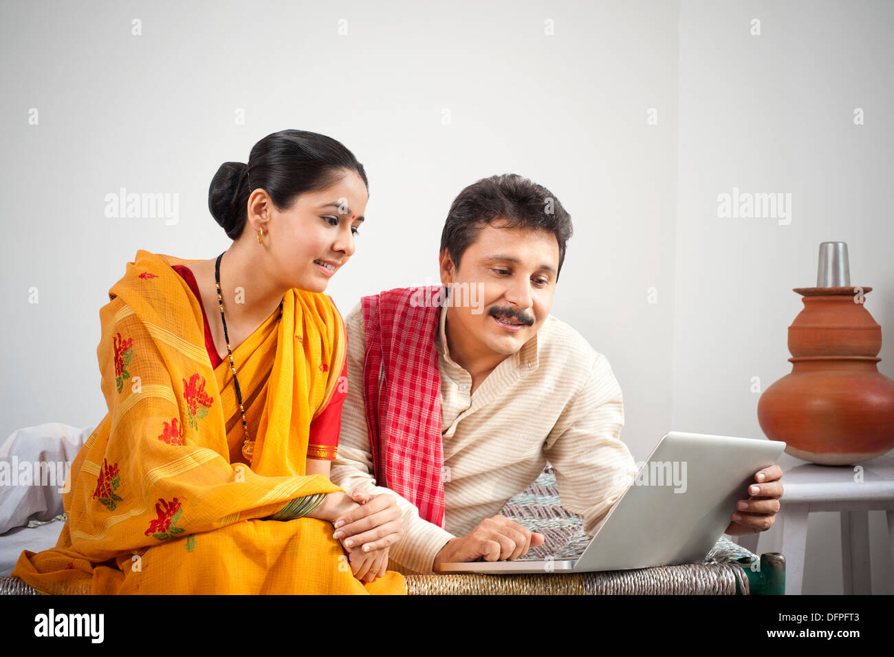 Man using a laptop while his wife looking Stock Photo