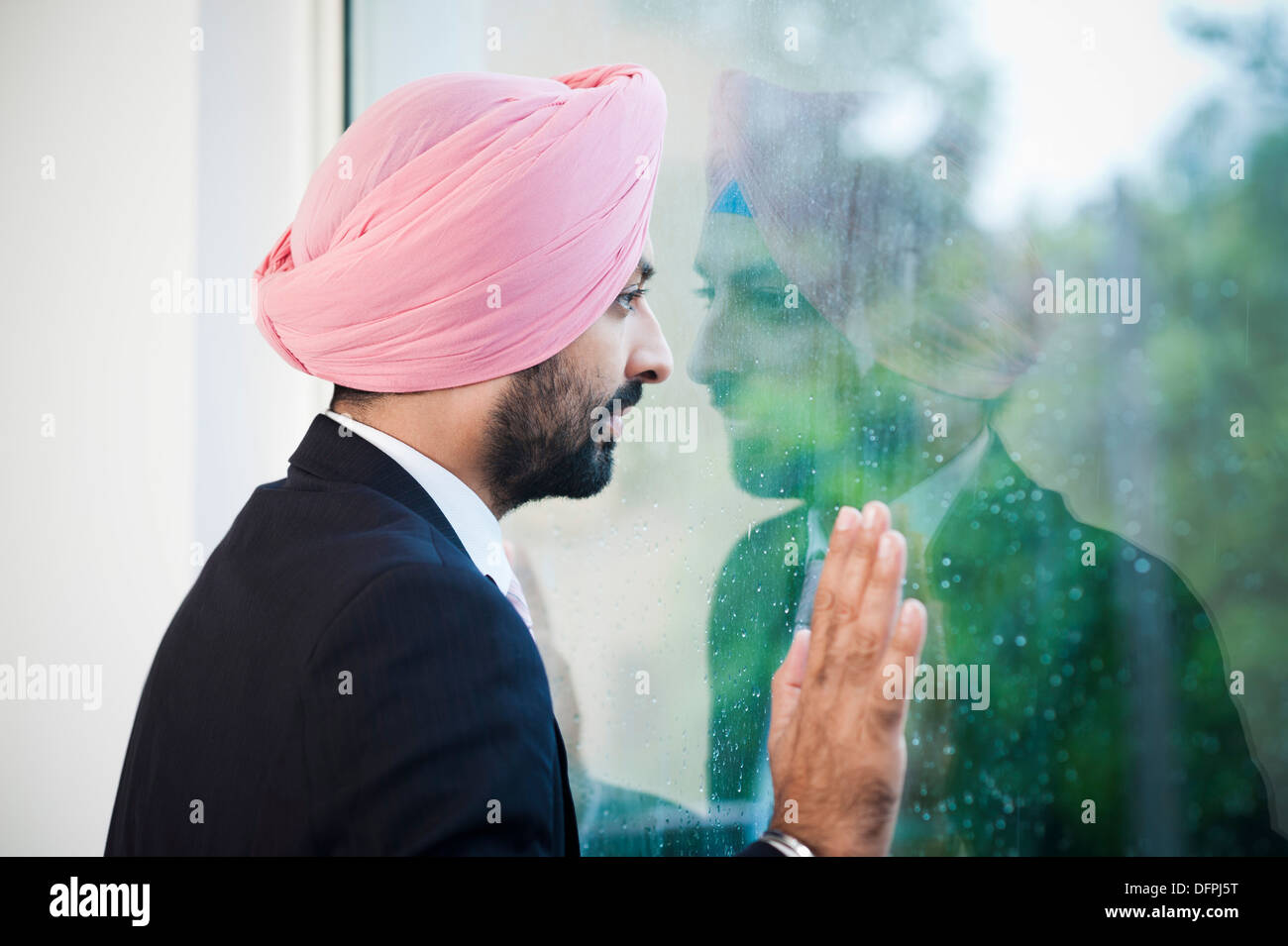 Businessman looking out of a window and thinking Stock Photo