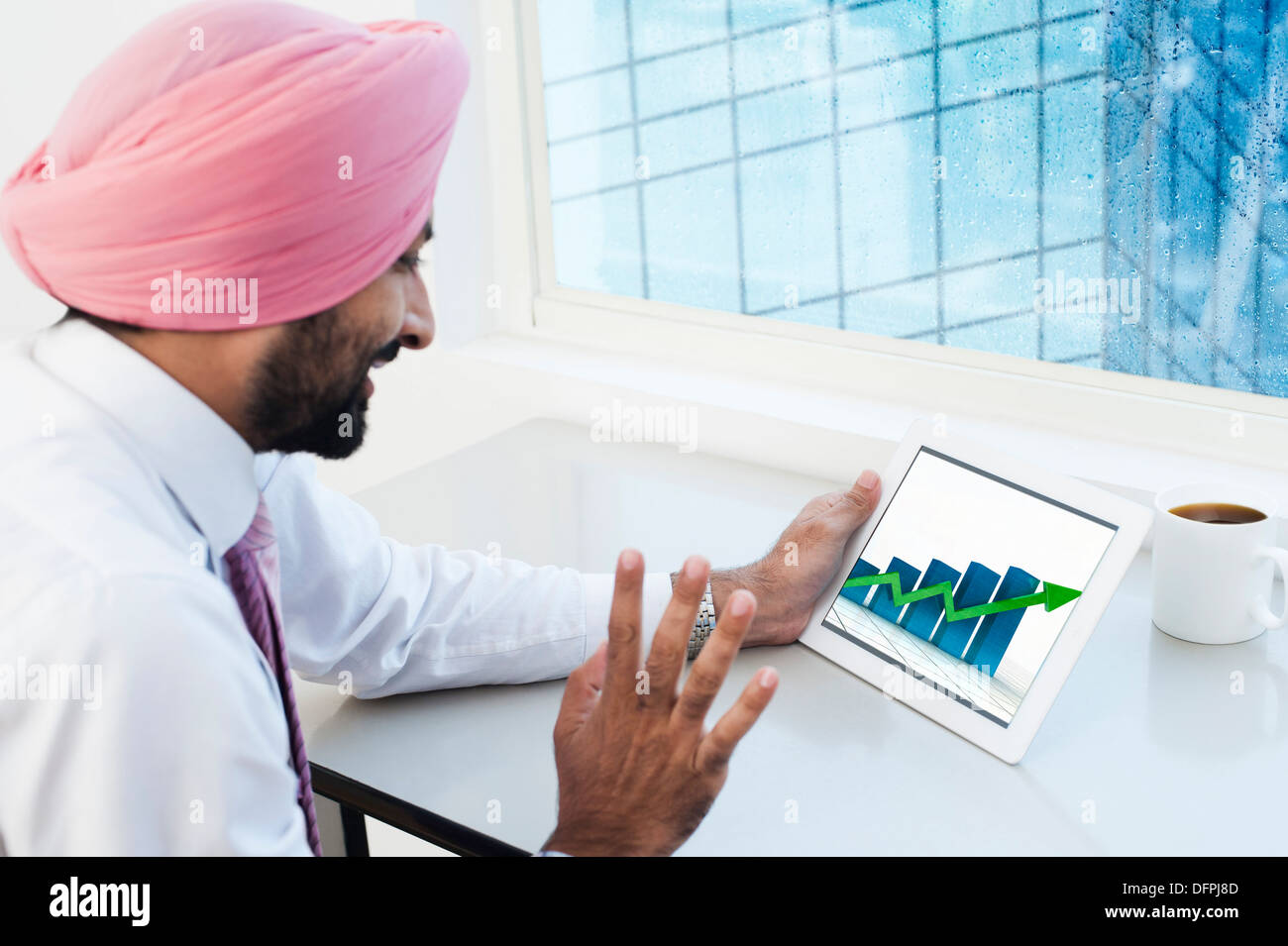 Businessman analyzing graph on a digital tablet Stock Photo