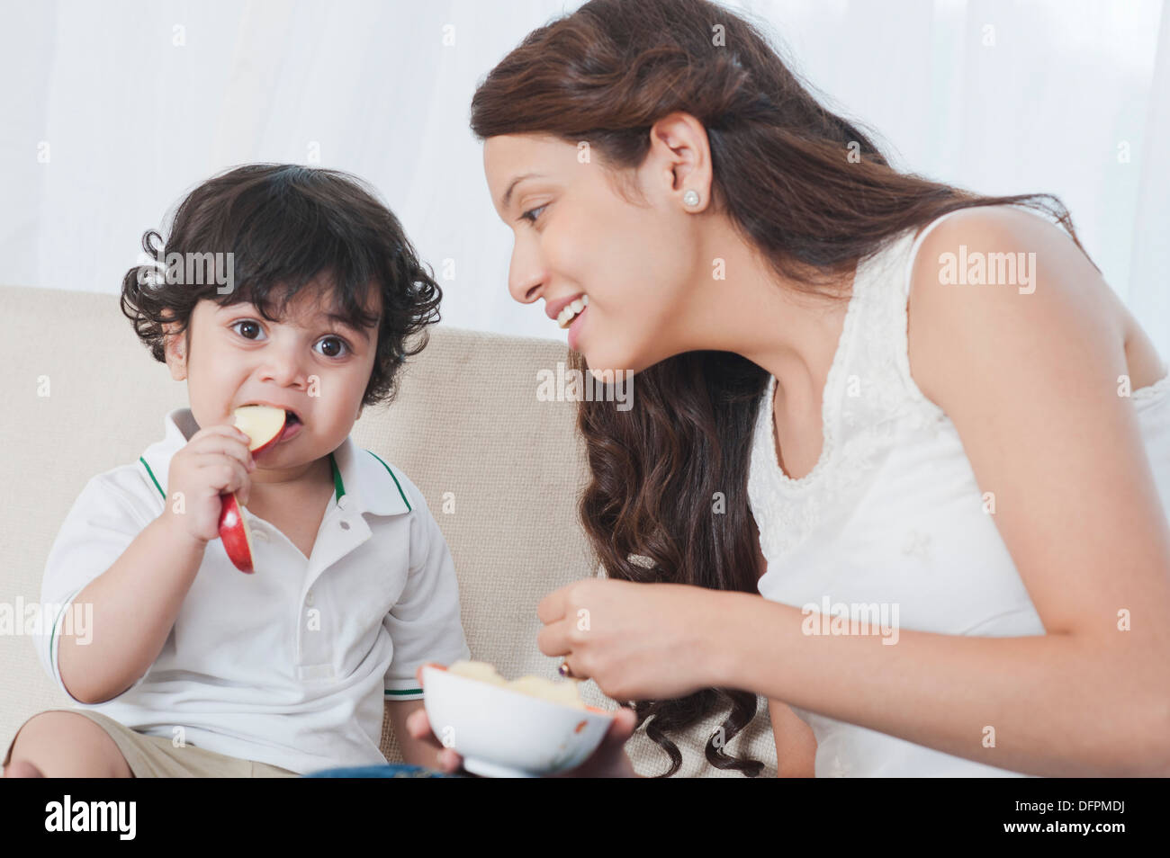 Woman feeding apple to her son Stock Photo Alamy