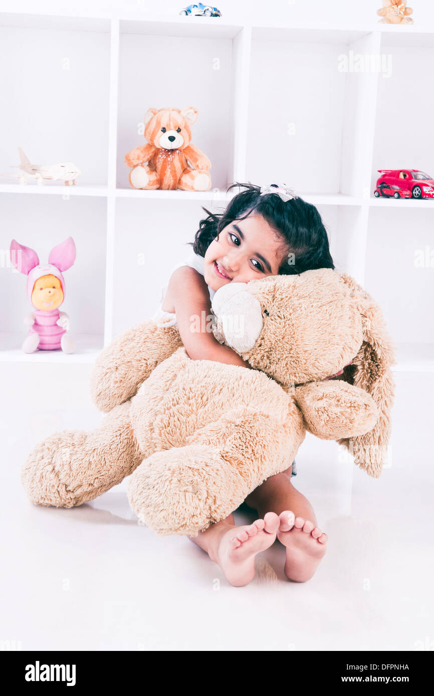 Girl holding a teddy bear and smiling Stock Photo - Alamy
