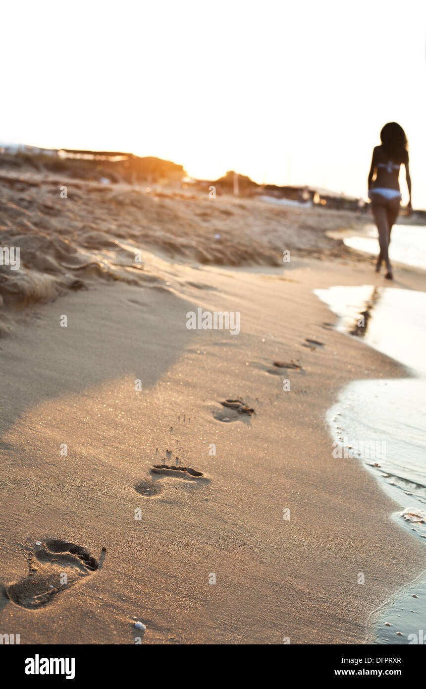 A young woman walking on the sand Stock Photo Alamy