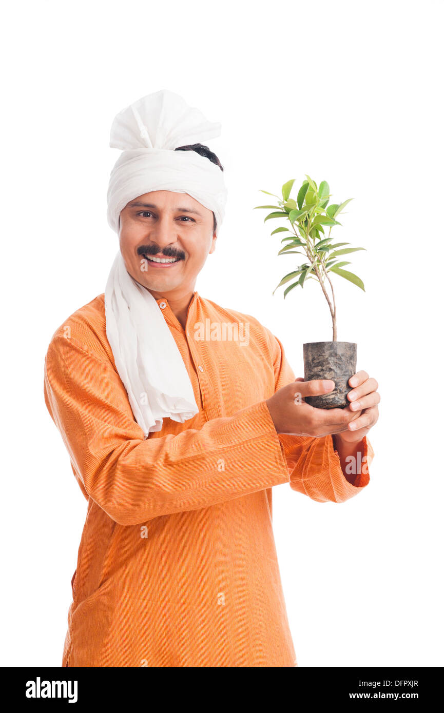 Portrait of a farmer holding a potted plant and smiling Stock Photo - Alamy