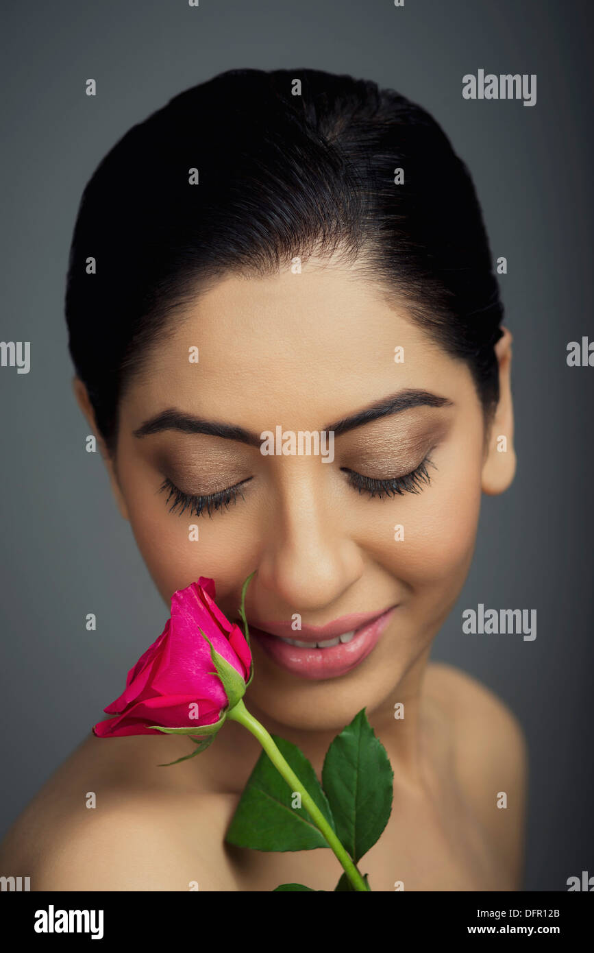 Close-up of a beautiful woman smelling rose Stock Photo - Alamy