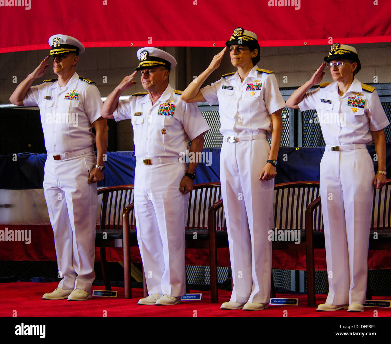 Capt. Ray Houk, left, Adm. Bill Gortney, commander of U.S. Fleet Forces, Rear Adm. Gretchen S. Herbert, and Rear Adm. Diane E. H. Webber salute the colors during the Navy Cyber Forces change of command ceremony at Joint Expeditionary Base Little Creek. We Stock Photo