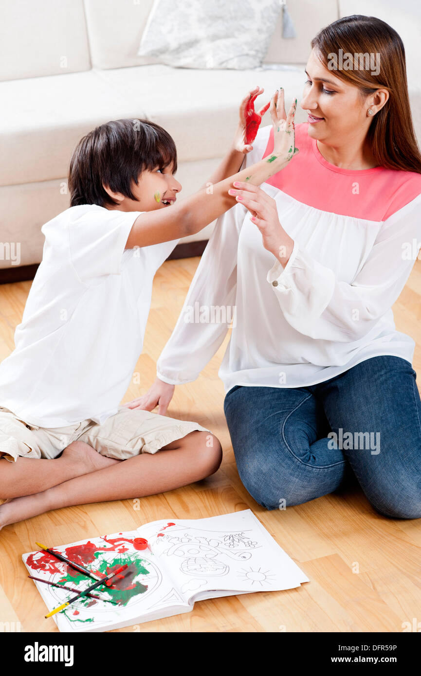 Boy showing his painted hands to his mother Stock Photo