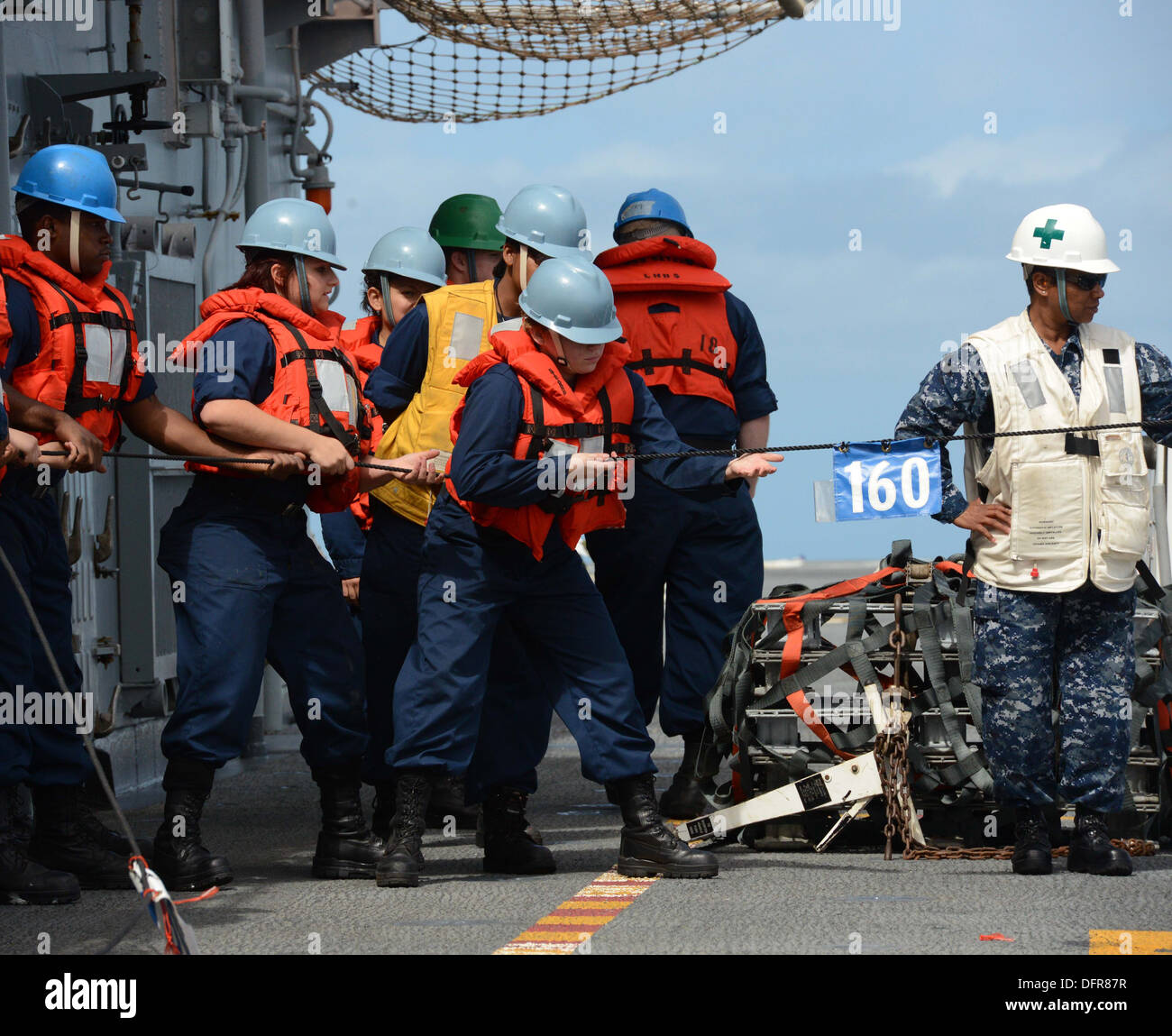 Sailors assigned to the ship's deck department heave a line measuring