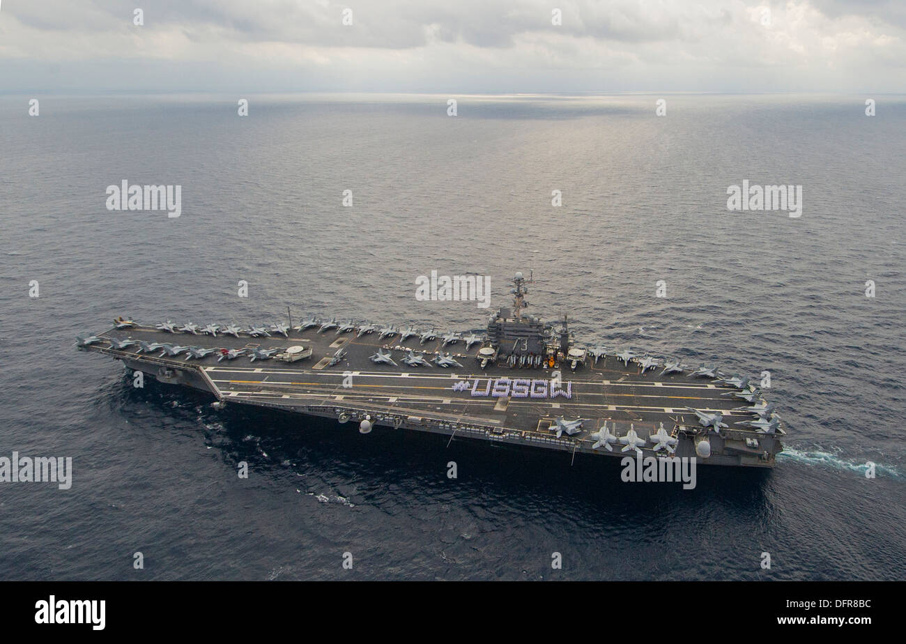 USS George Washington (CVN 73) stand in formation to spell out #USSGW on the flight deck. The purpose of the #USSGW photo is to Stock Photo