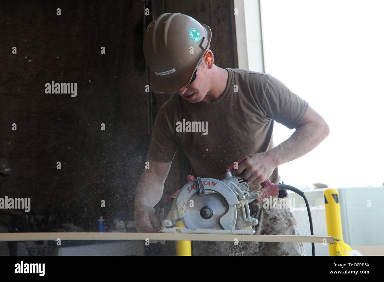 Kandahar Airfield, Afghanistan - US Navy Builder 1st Class Mark Campbell, attached to Naval Mobile Construction Battalion (NMCB) 28, cuts wood to be used as molding in a new office space, Oct. 2, 2013. NMCB 28 is based out of Barksdale Air Force Base, Shr Stock Photo