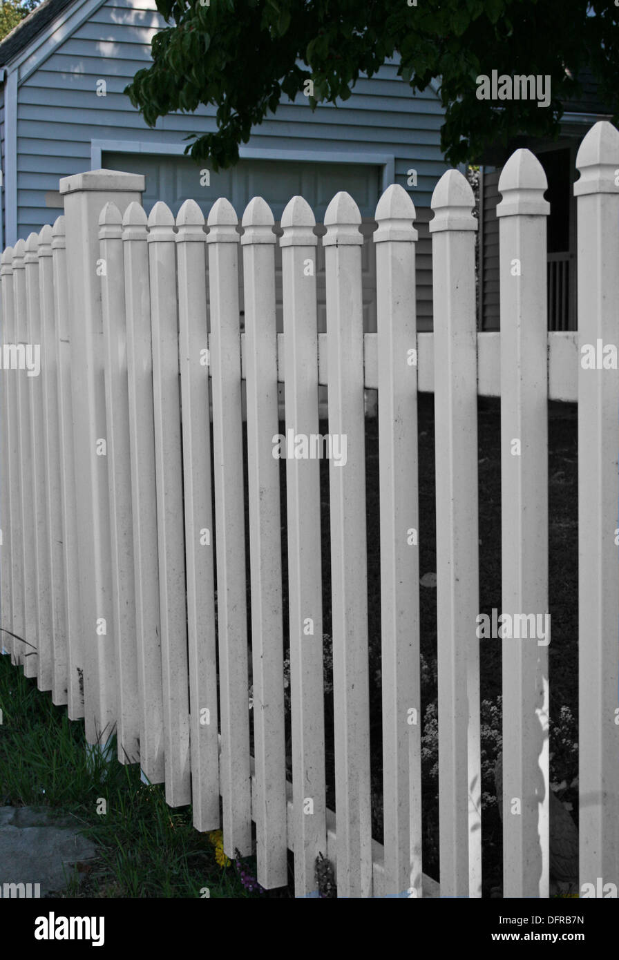 White picket fence in yard of home Stock Photo