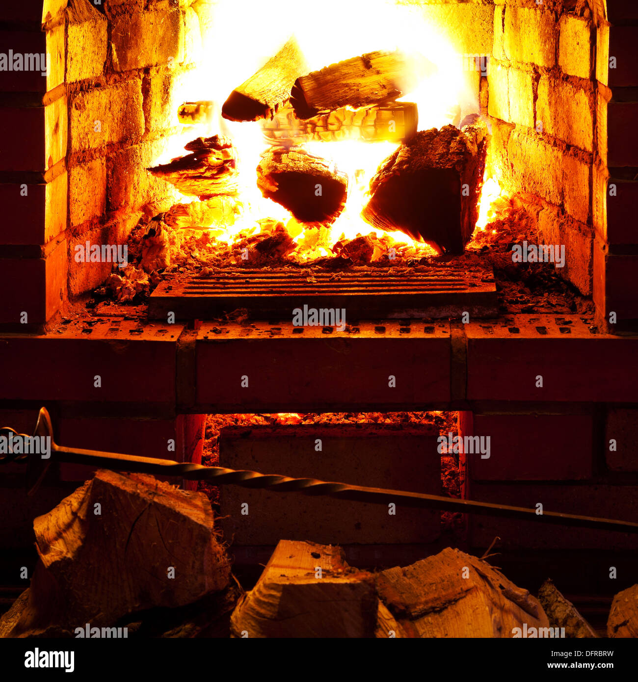 poker, firewood and near fireplace in evening time Stock Photo
