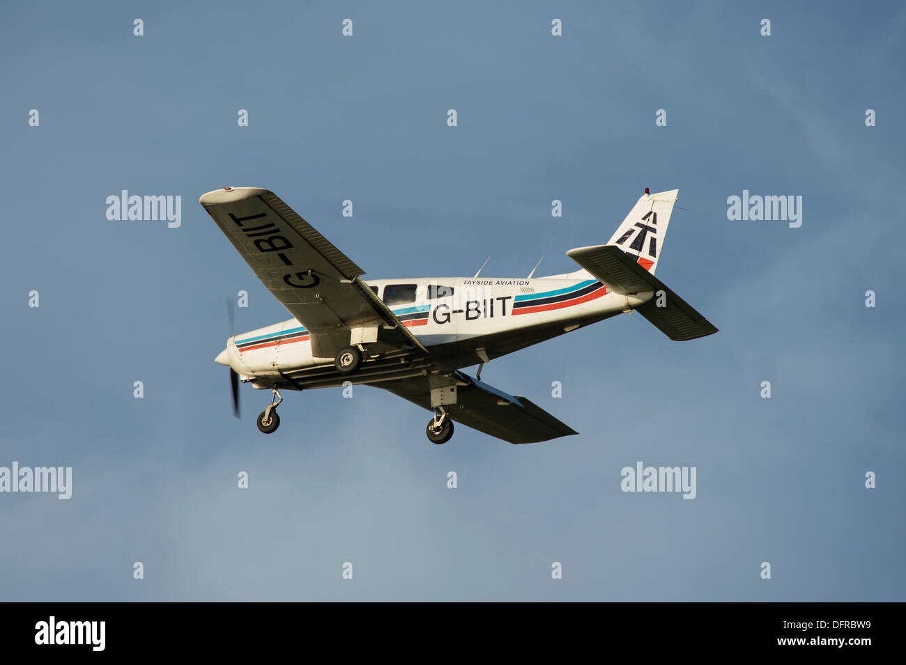 Light aircraft in Tayside Aviation colours flying overhead on a summer's day. Stock Photo