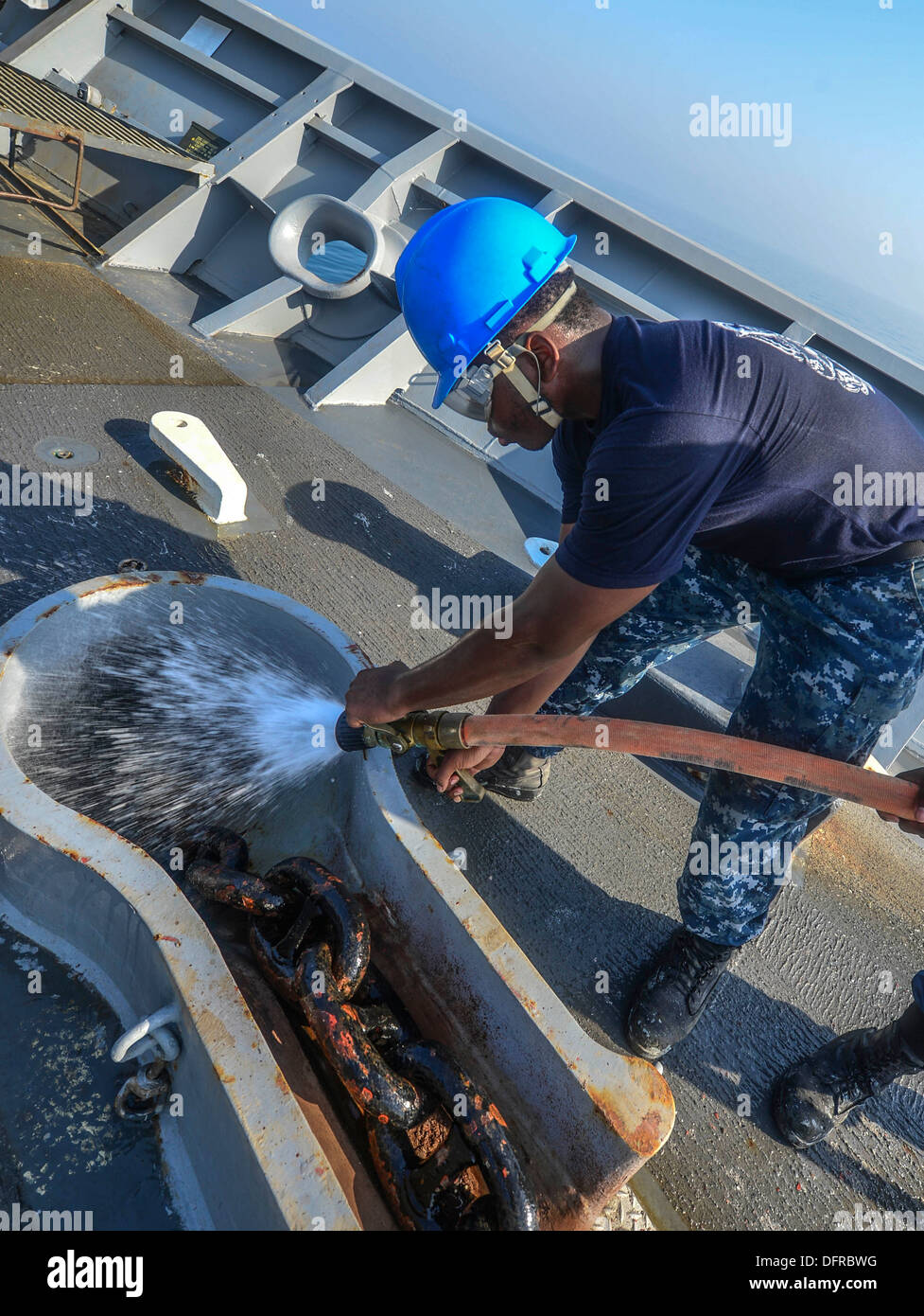 Boatswain's Mate Seaman Marsell James rinses the anchor chain on the
