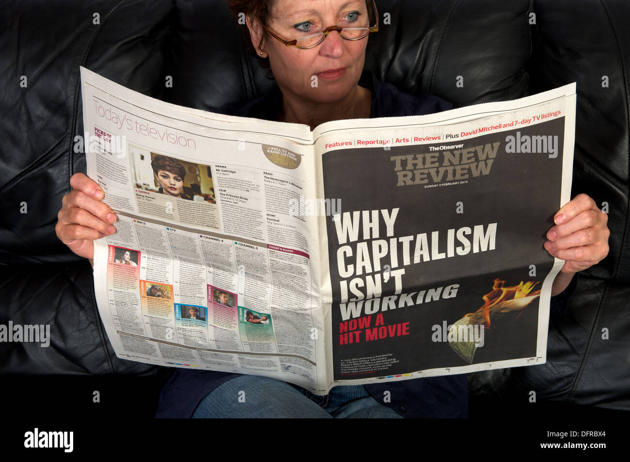 Woman reading The Observer newspapers The New Review supplement Stock Photo