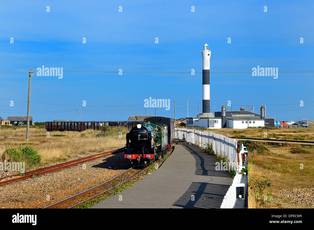 Dungeness lighthouse with steam train in foreground approaching station