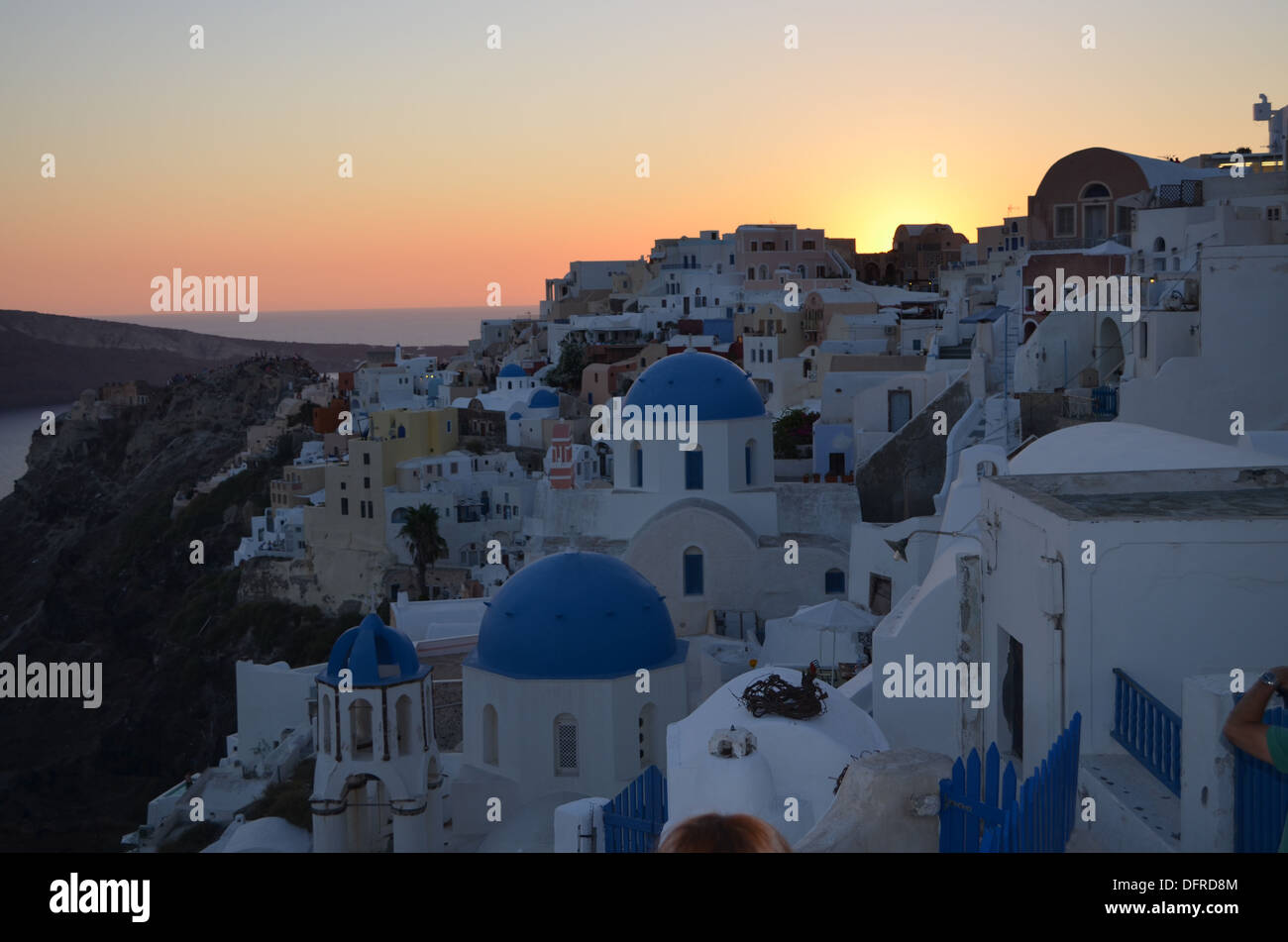 Sunset on Oia, Santorini island. The small Greek Church looks over the many houses & hotels built where the great explosion in 1 Stock Photo