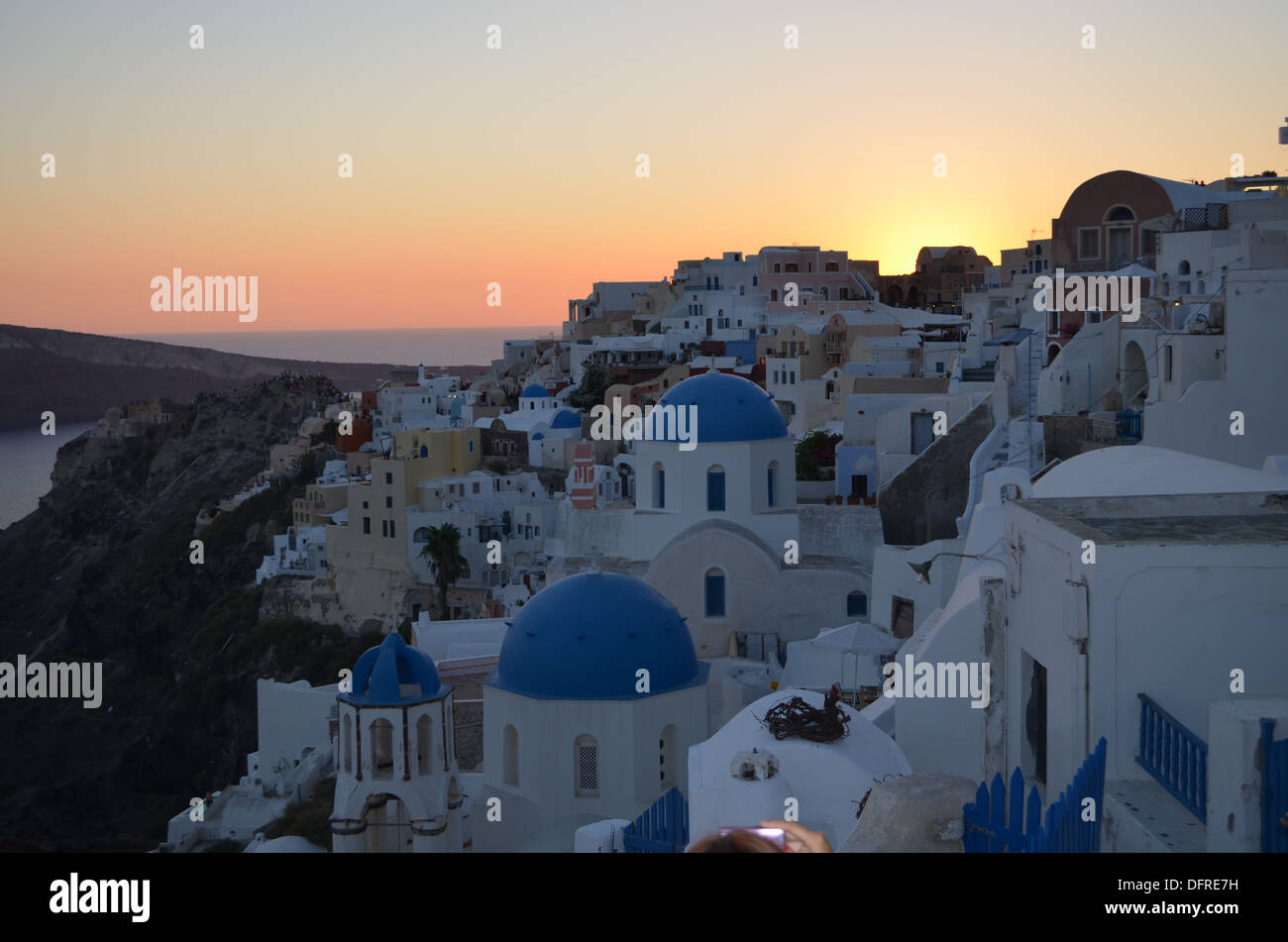 Sunset on Oia,Santorini island.The small Greek Church looks over  many houses & hotels built where the great explosion in1628 BC Stock Photo