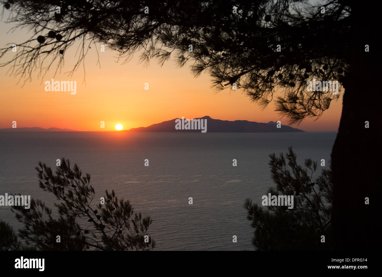 CYCLADES, GREECE. Sunrise over the Aegean as seen from Santorini (Thira), with the island of Anafi in the distance. Stock Photo