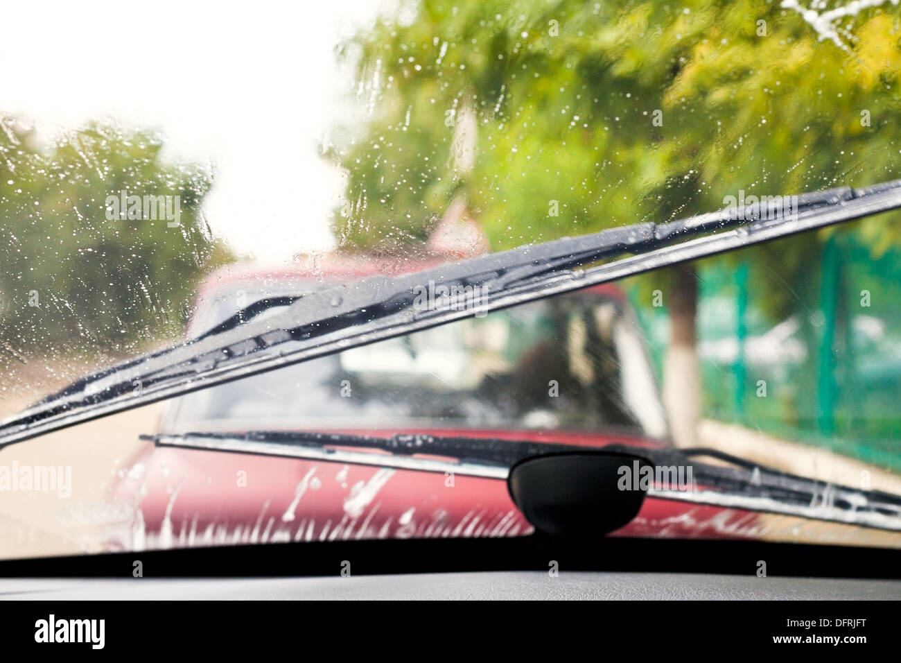 Car wipers wash windshield when driving in rain Stock Photo