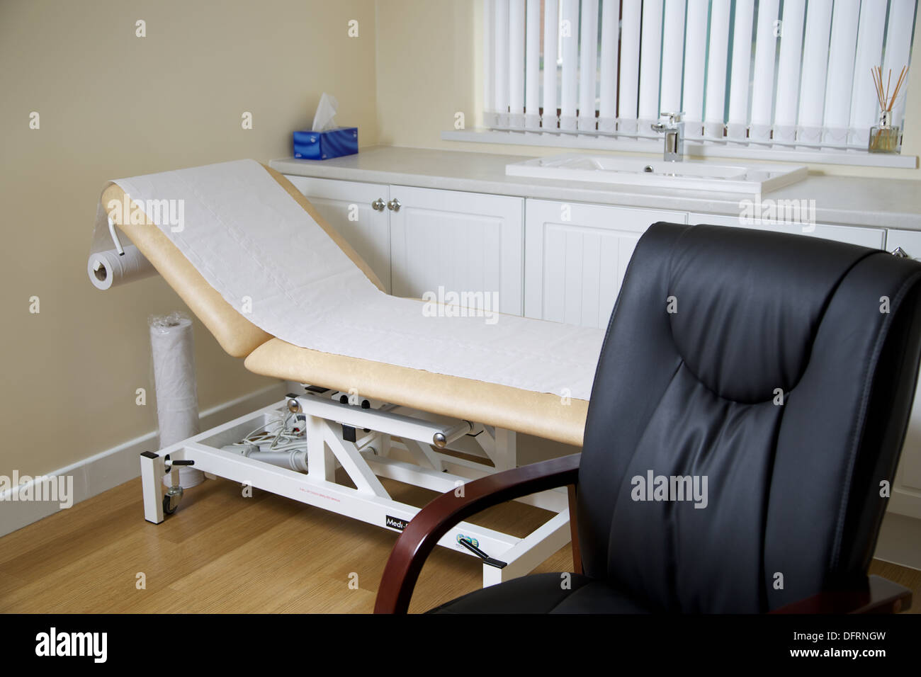 Interior of a GP doctor's surgery with an empty chair and bed Stock